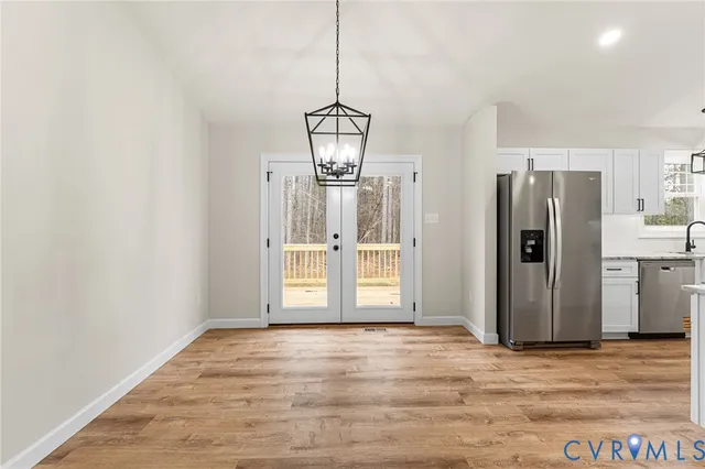 a view of a kitchen with wooden floor and a refrigerator