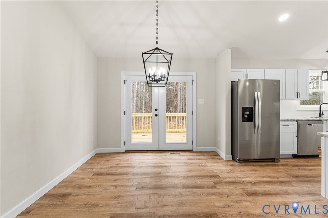 5132 Sunnyside Road Tappahannock, VA 22560 - Photo 7 of 28 a view of a kitchen with wooden floor and a refrigerator