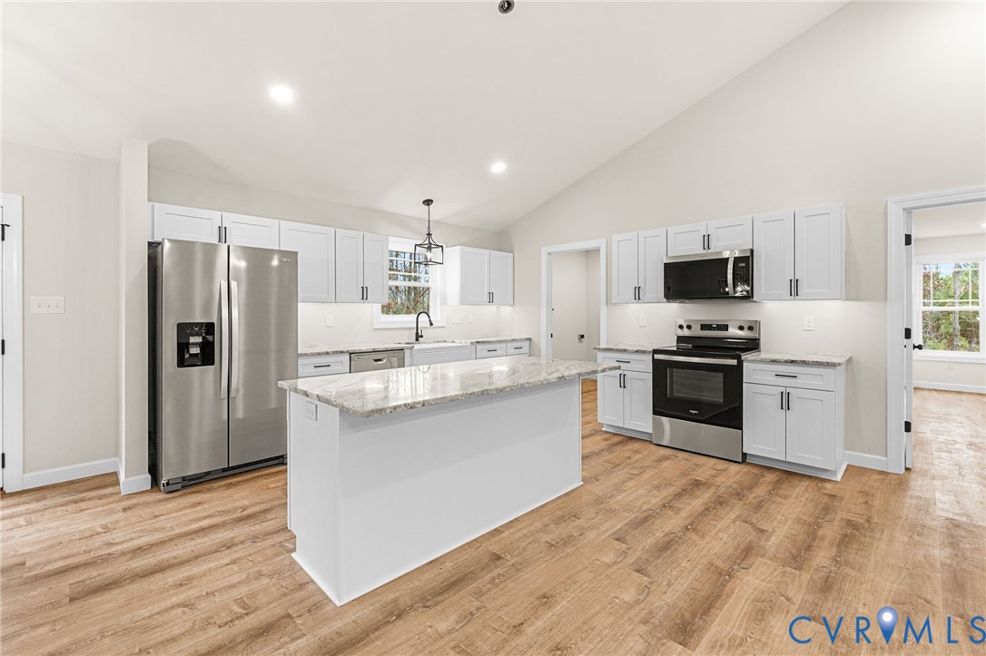 5132 Sunnyside Road Tappahannock, VA 22560 - Photo 10 of 28 a kitchen with granite countertop a refrigerator and a stove top oven
