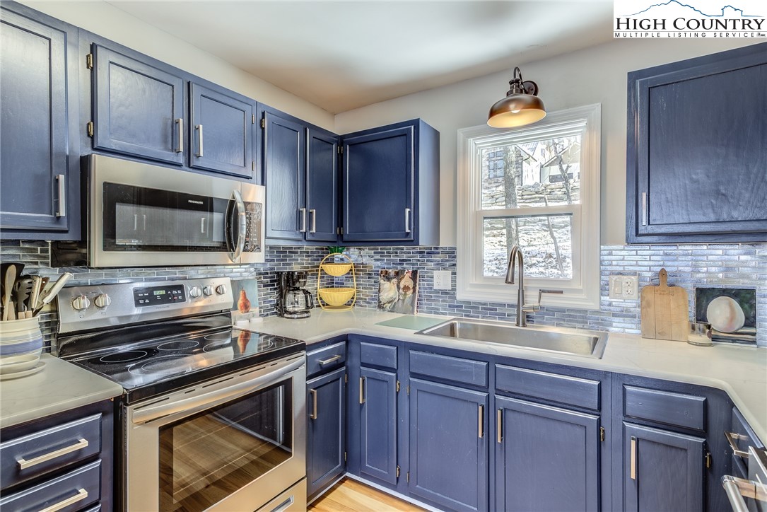 523 Pine Ridge Road Beech Mountain, NC 28604 - Photo 12 of 42 a kitchen with sink a microwave a stove and cabinets
