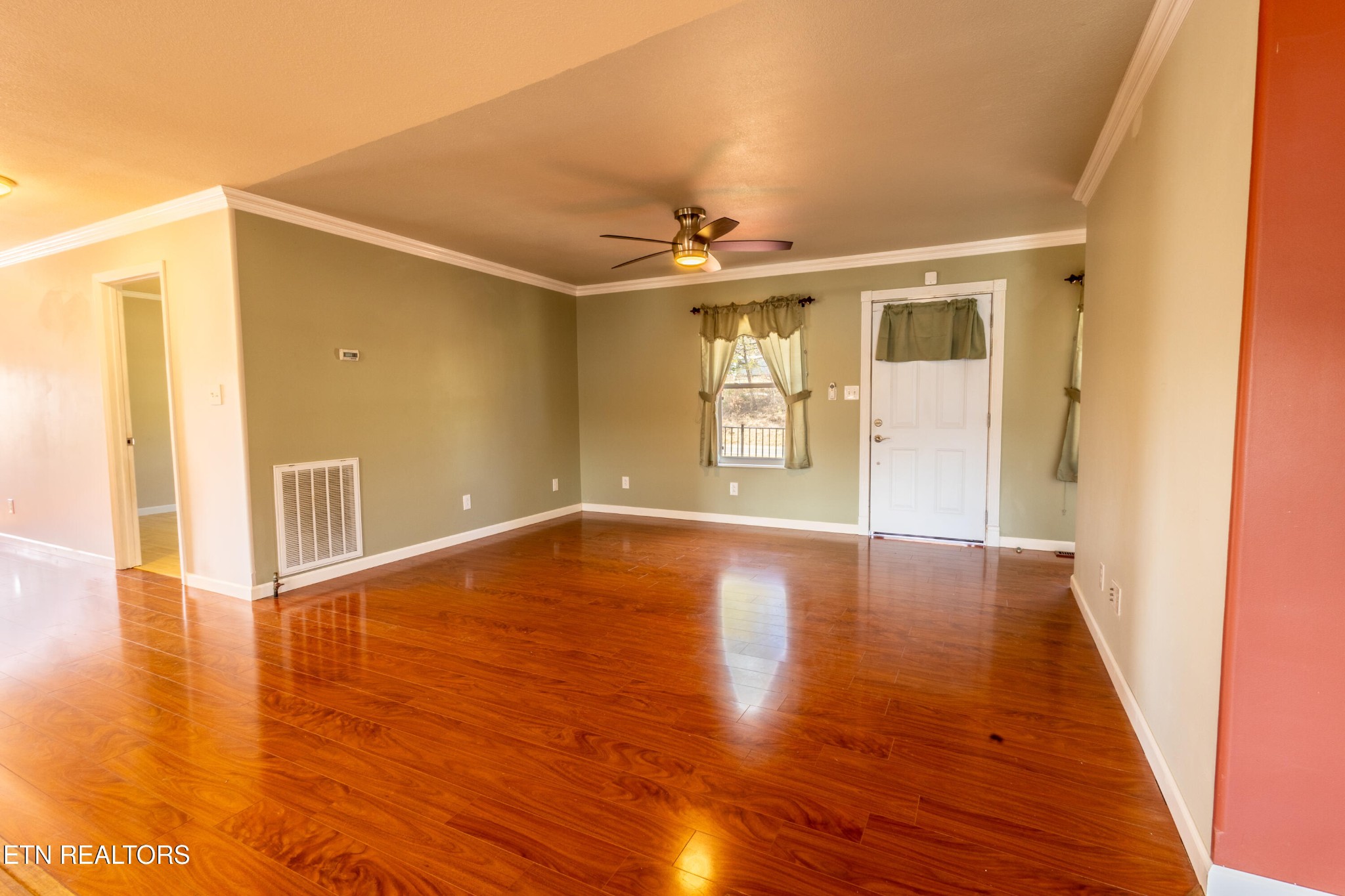 1208 Dutch Valley Road Clinton, TN 37716 - Photo 3 of 21 a view of an empty room with wooden floor and a window