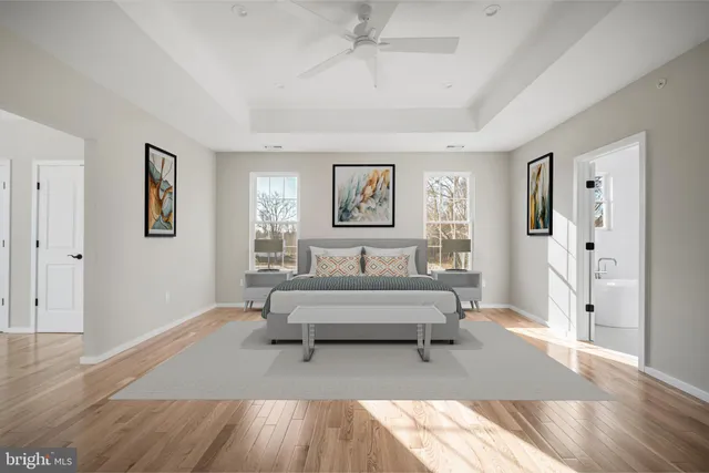 a spacious bedroom with a bed a table and painting on the wall