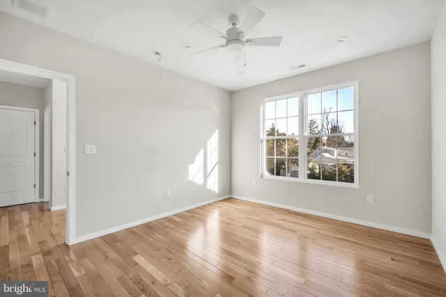 a view of empty room with wooden floor