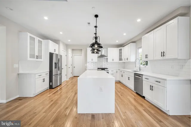 a view of a kitchen with wooden floor and electronic appliances
