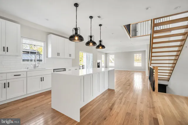 a kitchen with white cabinets and a stove with a sink