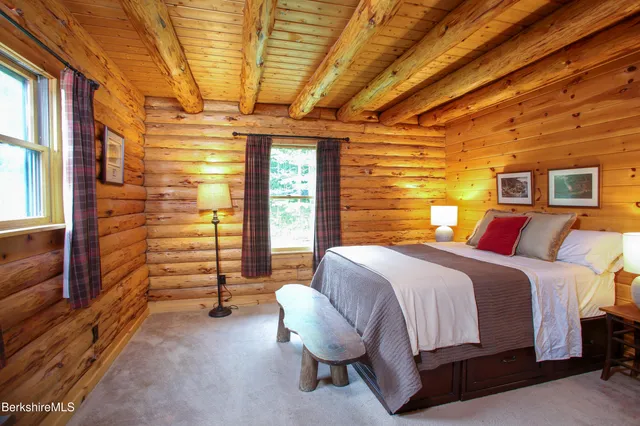 a spacious bedroom with a bed and wooden floor