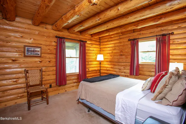 a bedroom with a bed and a dresser next to a window
