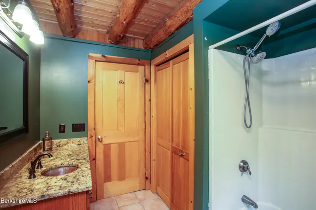 a bathroom with a granite countertop shower and a sink