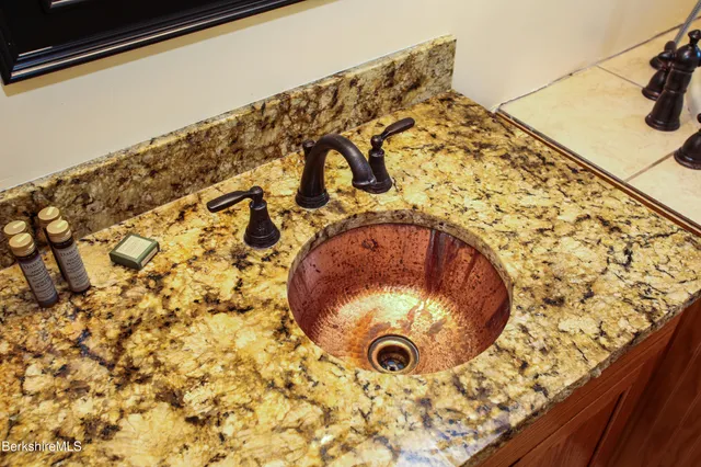 a bathroom with a granite countertop sink and a mirror