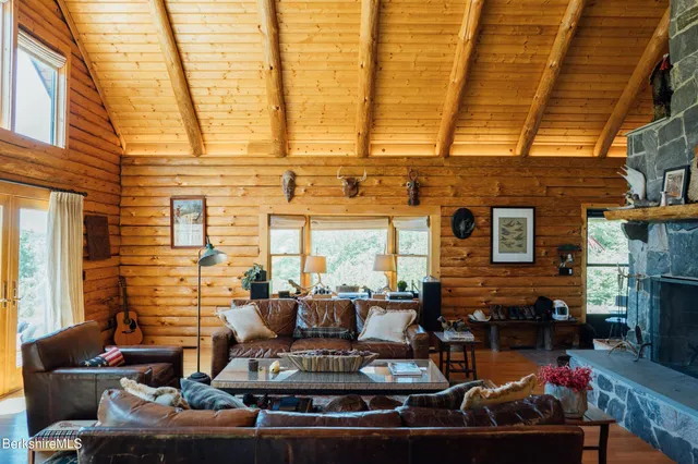 a living room with fireplace furniture and a large window