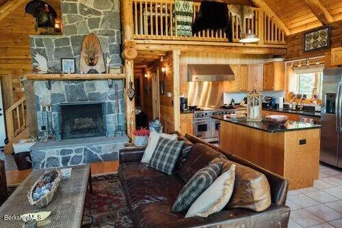 a living room with furniture a fireplace and kitchen view