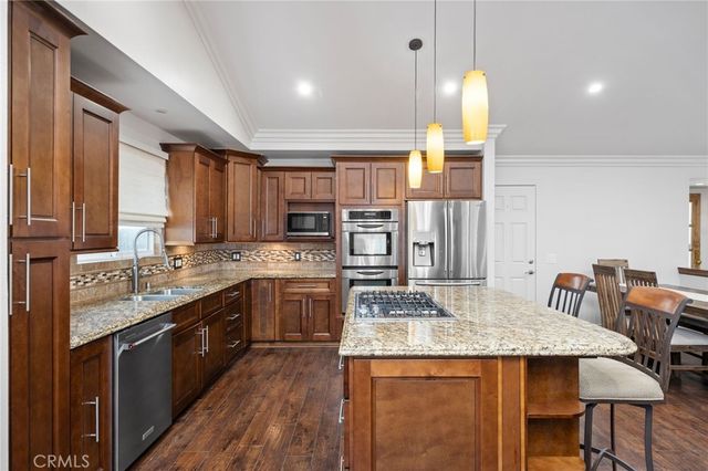 a kitchen with stainless steel appliances granite countertop wooden cabinets and sink