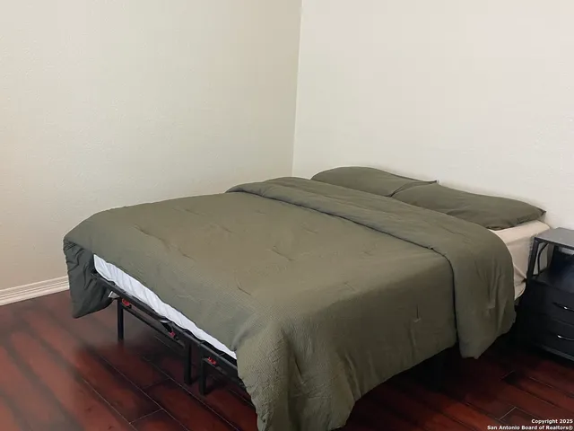 a bed sitting in a bedroom next to a wooden cabinet