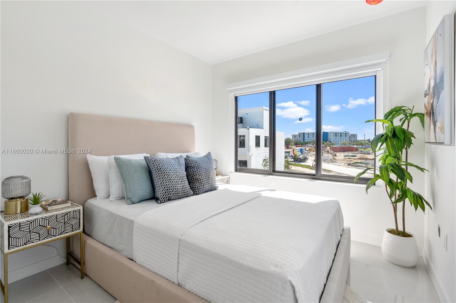 26119 Southwest 145th Court Homestead, FL 33033 - Photo 16 of 25 a bed sitting in a bedroom next to a large window with potted plants