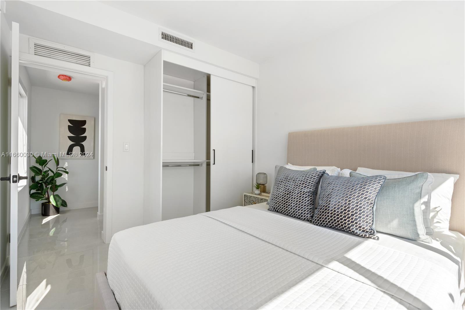 26119 Southwest 145th Court Homestead, FL 33033 - Photo 17 of 25 a bedroom with a bed and a potted plant