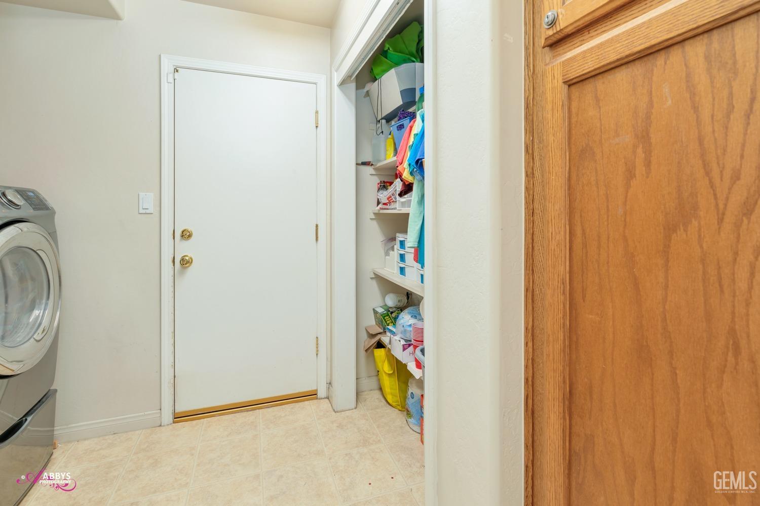 Undisclosed Address Bakersfield, CA 93312 - Photo 30 of 53 Laundry off of 3 car garage with storage cabinet and storage closet