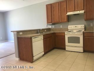 8612 Ribbon Falls Lane Jacksonville, FL 32244 - Photo 2 of 13 a kitchen with a stove top oven sink and cabinets
