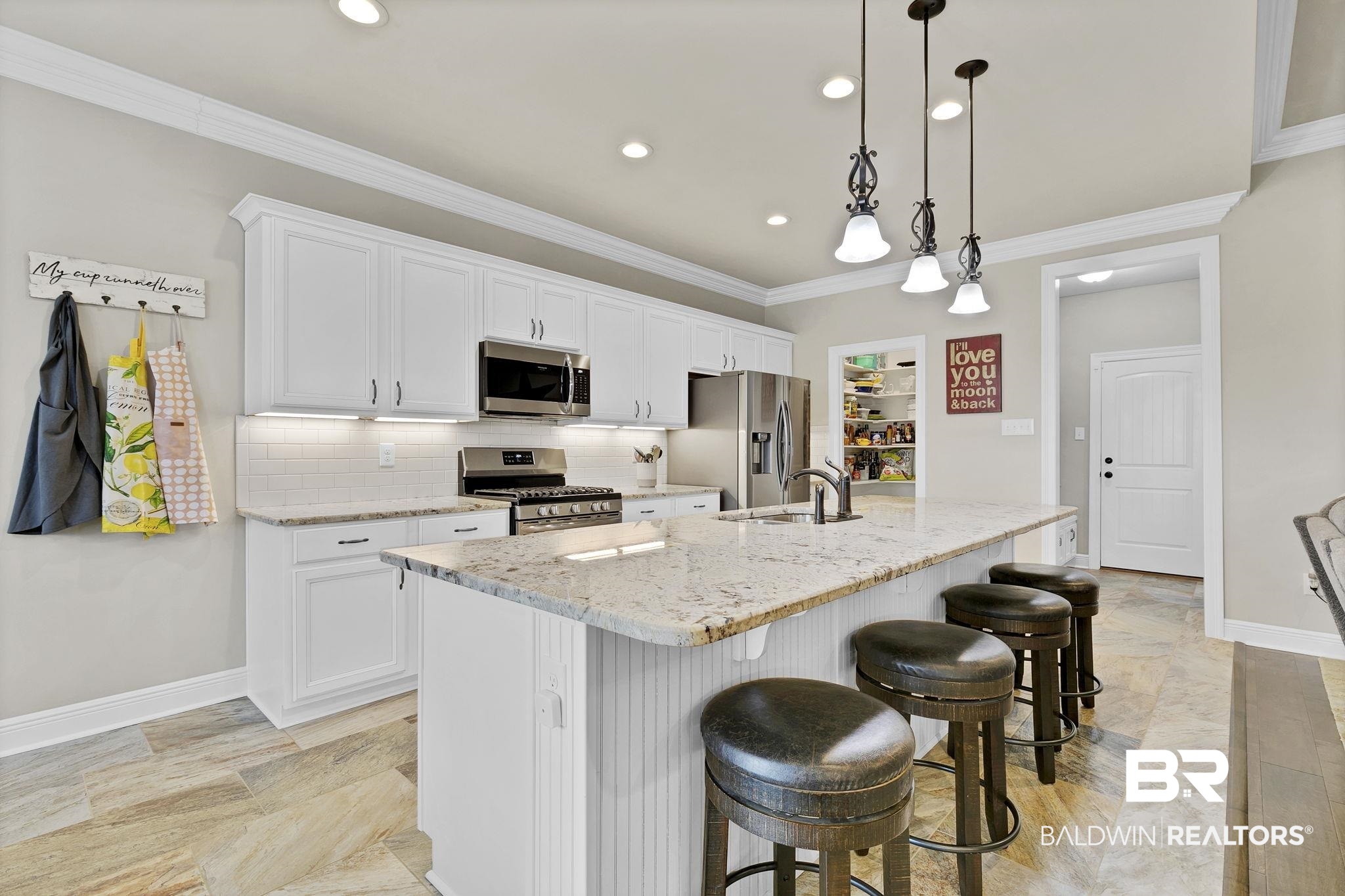 11247 Thistledown Loop Spanish Fort, AL 36527 - Photo 13 of 72 Kitchen featuring stainless steel appliances, a center island with sink, crown molding, and a sink