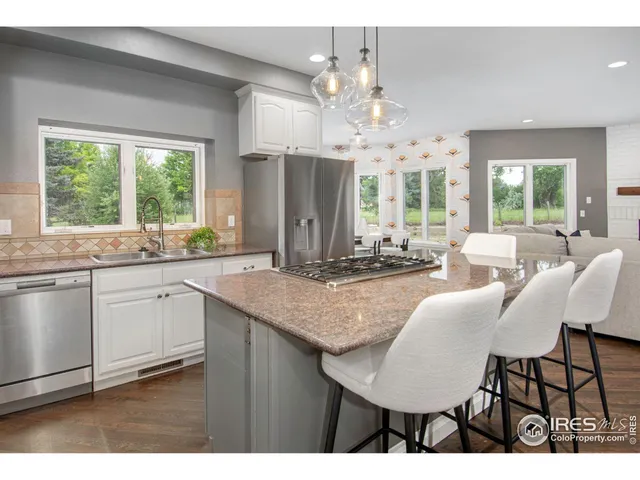 a view of kitchen with granite countertop cabinets table and chairs