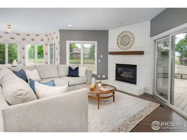 a living room with furniture a clock and a fireplace