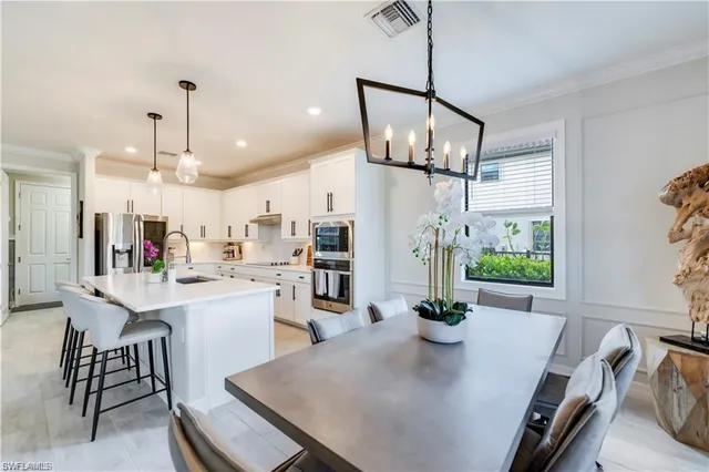 a view of a dining room and livingroom with furniture wooden floor a chandelier