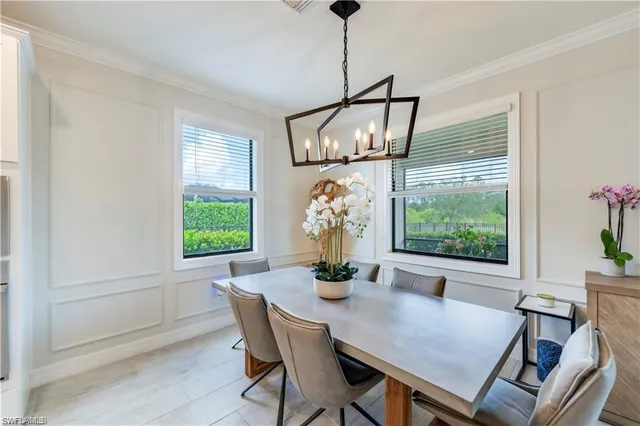 a dining room with furniture a chandelier and wooden floor