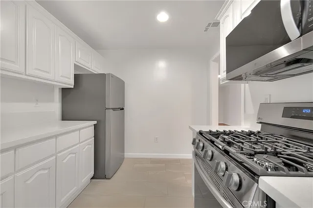 a kitchen with white cabinets and white stove