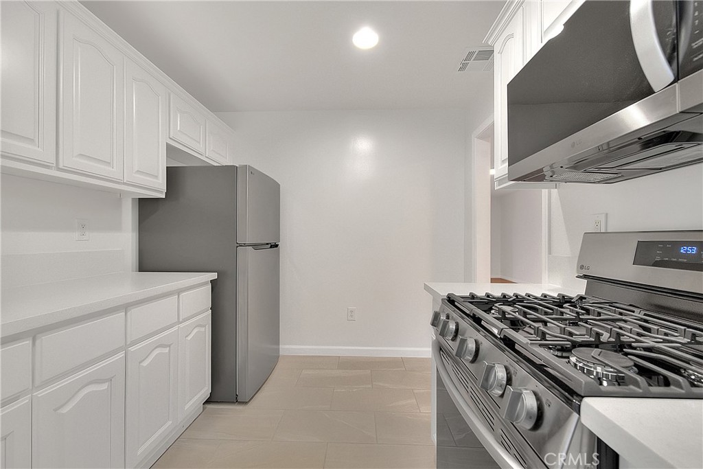 3105 Walton Avenue Los Angeles, CA 90007 - Photo 13 of 38 a kitchen with white cabinets and white stove
