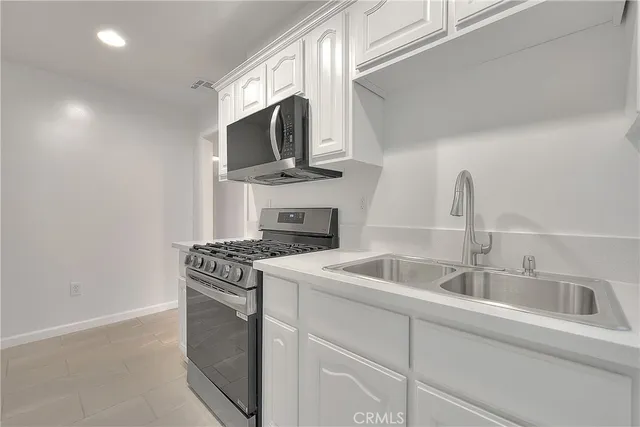 a kitchen with stainless steel appliances granite countertop a sink stove top oven and microwave
