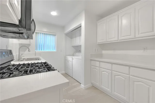 a kitchen with white cabinets and a stove