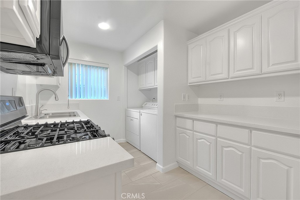 3105 Walton Avenue Los Angeles, CA 90007 - Photo 15 of 38 a kitchen with white cabinets and a stove