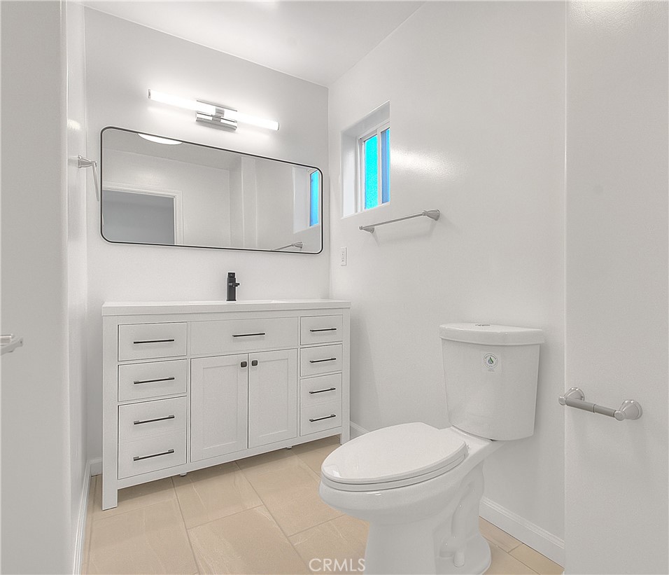 3105 Walton Avenue Los Angeles, CA 90007 - Photo 23 of 38 a bathroom with a toilet a sink a vanity and mirror