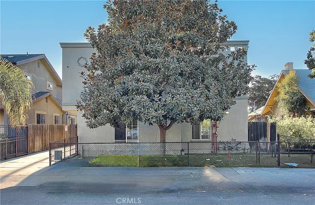 a view of a house with backyard and tree