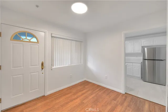 a view of empty room with wooden floor and window