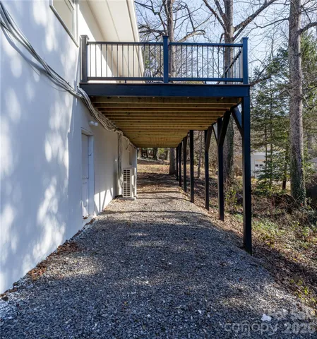 a view of backyard with large trees and wooden fence