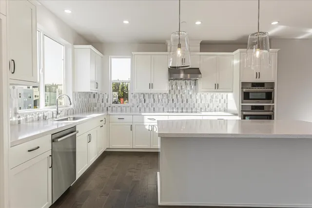 a kitchen with stainless steel appliances kitchen island a large island in the center and windows