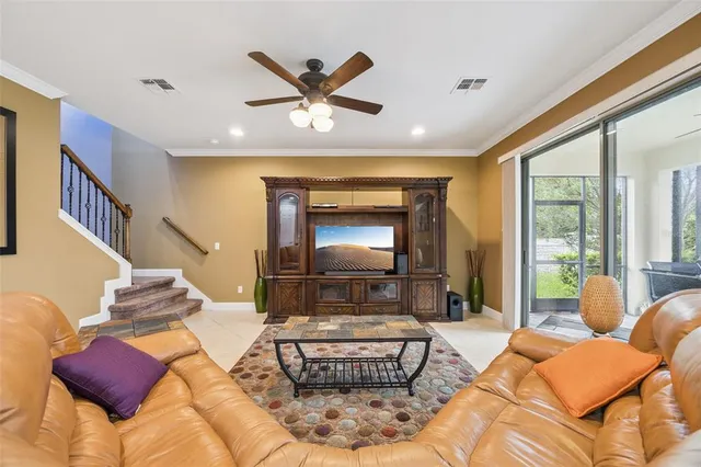 a living room with furniture kitchen view and a large window