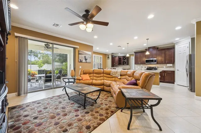 a living room with furniture kitchen view and a chandelier