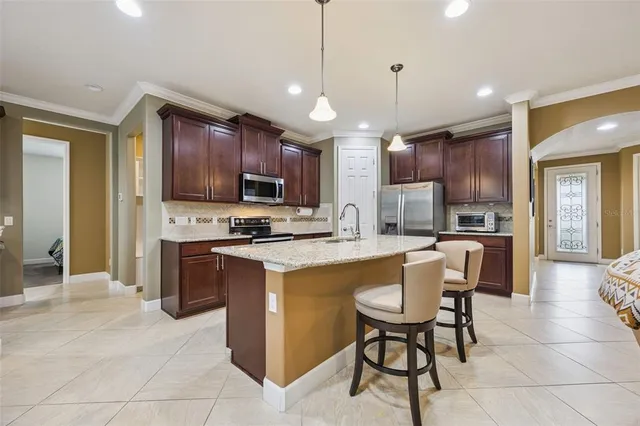 a kitchen with stainless steel appliances granite countertop a sink a oven and a refrigerator