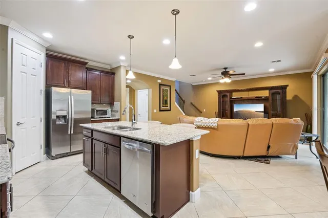a kitchen with stainless steel appliances granite countertop a sink a stove and a refrigerator