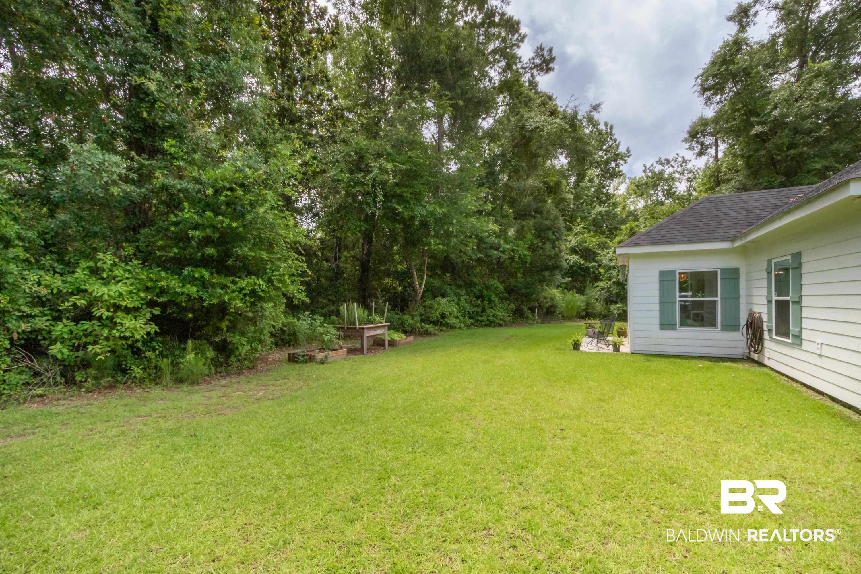 7472 Coopers Landing Road Foley, AL 36535 - Photo 38 of 40 Expansive green lawn bordering a single-story white siding residence