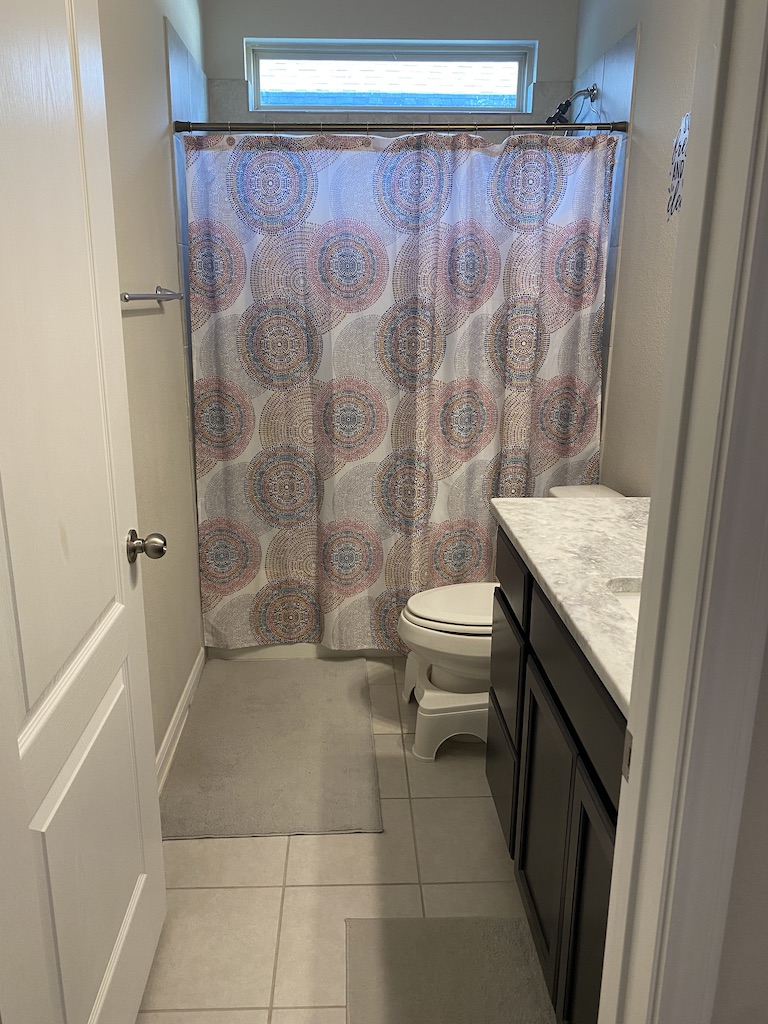 2034 Brisbane Way Bryan, TX 77807 - Photo 11 of 26 a bathroom with a granite countertop sink a toilet a mirror and shower