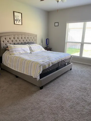 a large bed sitting in a bedroom next to a window