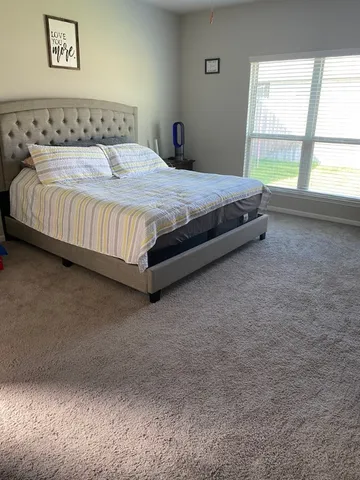 a bed sitting in a bedroom next to a window