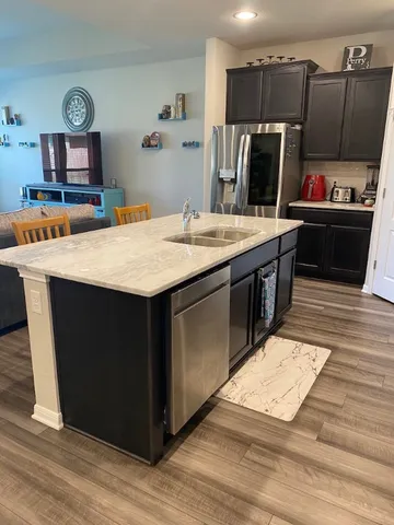 a kitchen with kitchen island wooden cabinets a sink stove and refrigerator