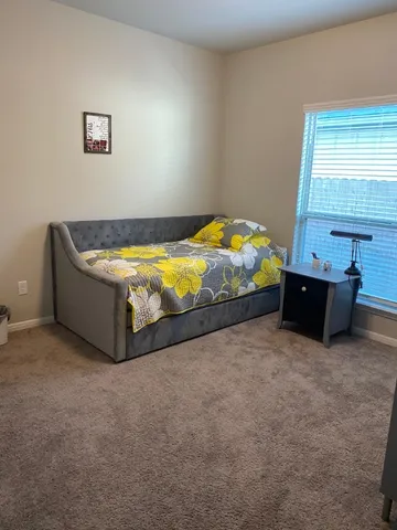 a bed sitting in a bedroom next to a window