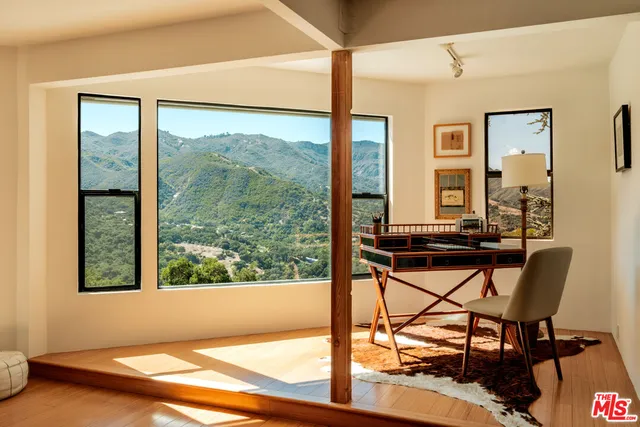 a bathroom with a bathtub a sink and large window