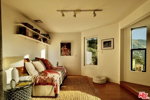 a bedroom with a bed next to a window