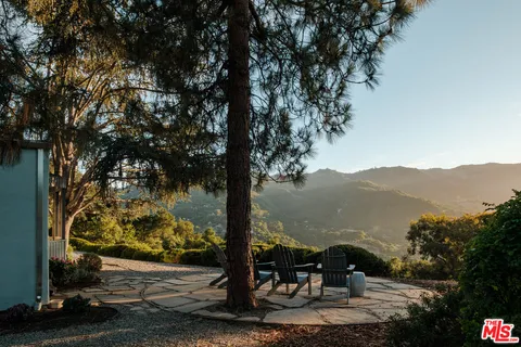 a view of a patio with table and chairs under an umbrella