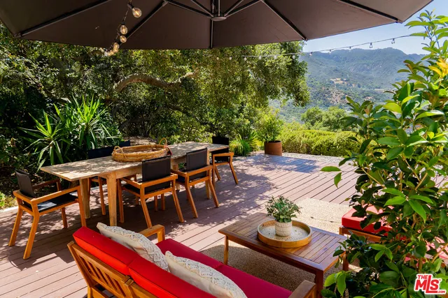 a view of a chairs and table on the roof deck
